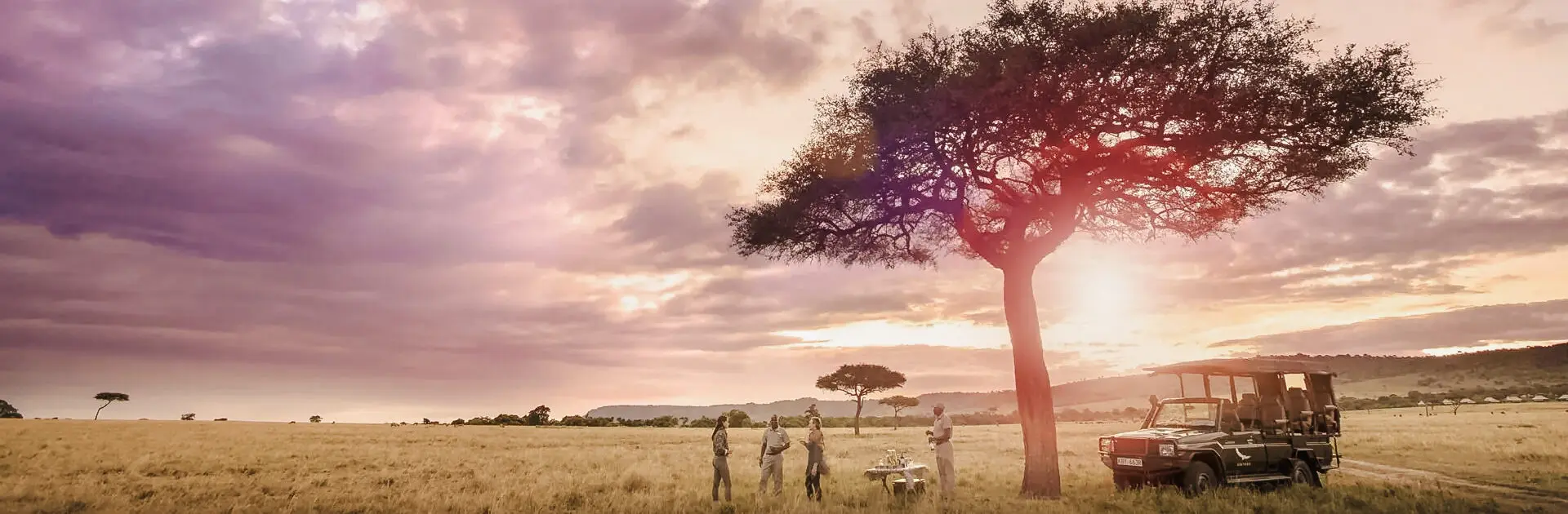 Huéspedes disfrutando de la puesta de sol en el Masai Mara en Kenia | Go2Africa