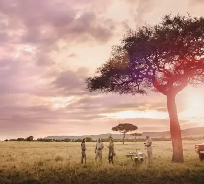 Huéspedes disfrutando de la puesta de sol en el Masai Mara en Kenia | Go2Africa