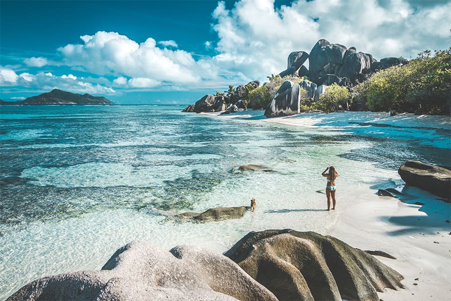 Mujer de pie en la playa de Denis, Seychelles.