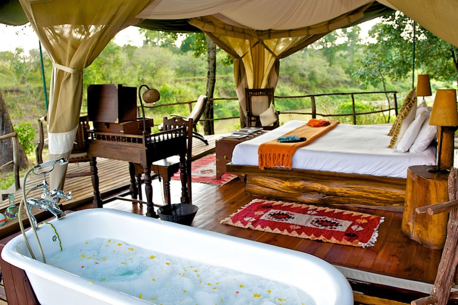 An open sided tent with bathtub and two chairs overlooking the surrounding bush | Go2Africa