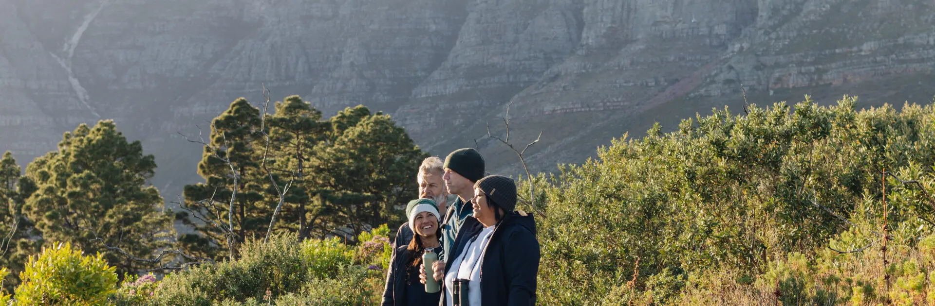 Los miembros del equipo de Go2Africa permanecen juntos contemplando el paisaje con la Montaña de la Mesa al fondo | Go2Africa