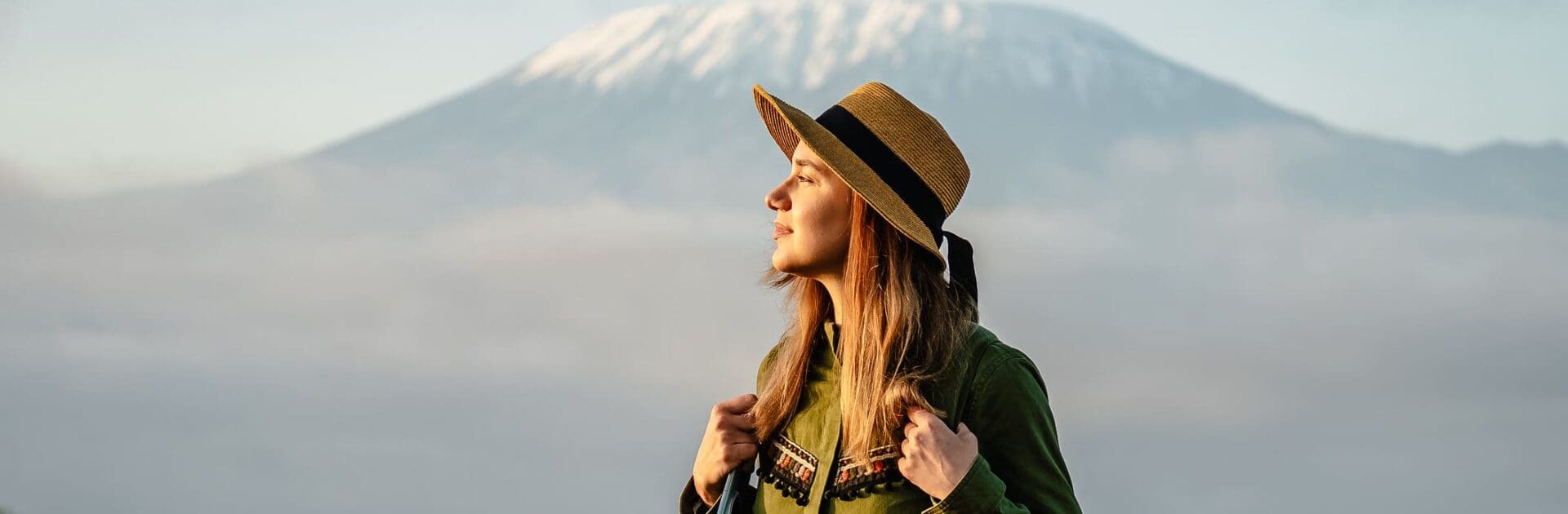 Una hermosa joven con sombrero frente al monte Kilimanjaro en Tanzania | Go2Africa