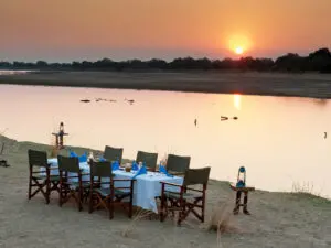 Puesta de sol junto al río Luangwa y una mesa preparada para una cena a la luz de las estrellas: los safaris no pueden ser mejores.