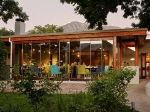 Der Living Room in Franschhoek mit Blick auf die Gärten ist ein wunderbarer Ort, um sich zu entspannen oder bei einem Glas Wein aus der Region zu plaudern.