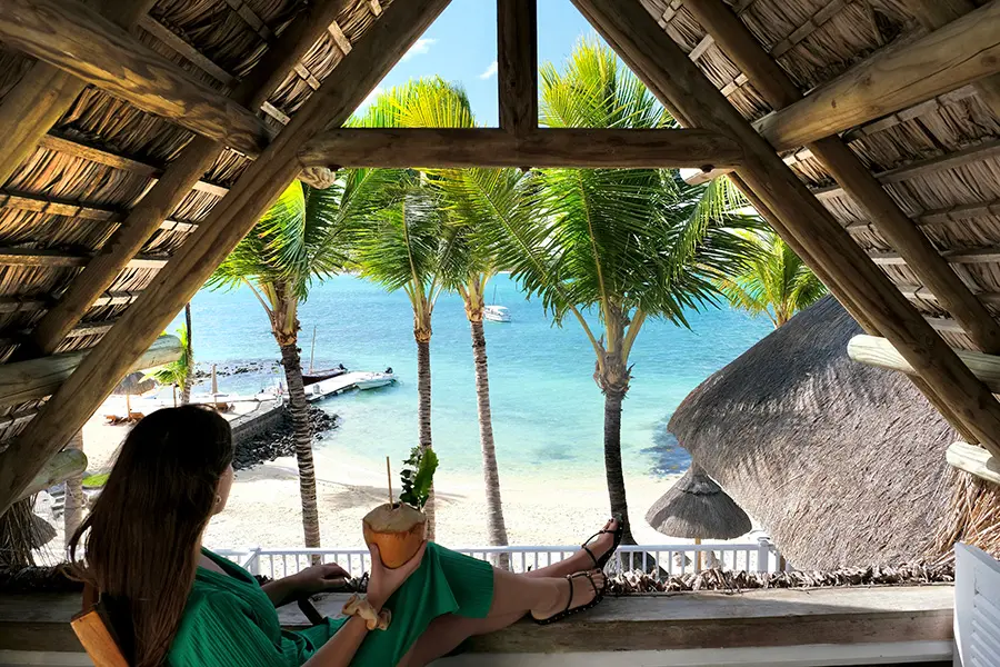 A woman overlooking the beach and palm trees from 20 Degrees Sud in Mauritius | Go2Africa