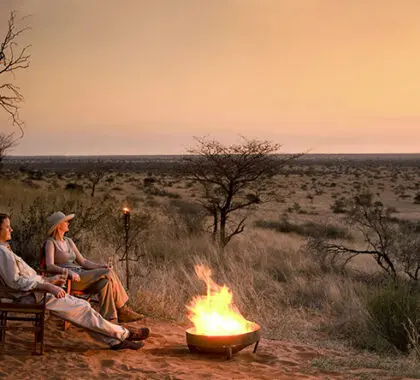 Siéntese y deje que el silencioso drama de una puesta de sol en el Kalahari le invada en Motse Lodge.