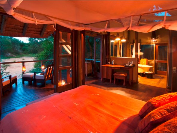 Your suite at Rhino Post Safari Lodge overlooks the Mutlumuvi River & features its own bathroom & viewing deck.