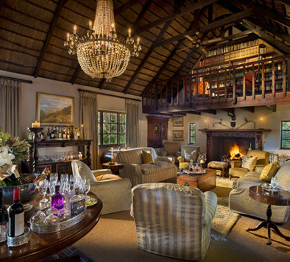 The library has a warm and welcoming atmosphere where guests may enjoy a tall drink by the fireplace.