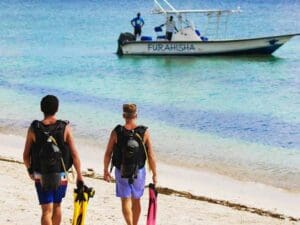 Pasee hasta la playa desde su suite y suba a bordo de la lancha de buceo.