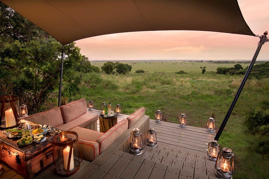 Una zona para sentarse y farolillos bajo una lona con vistas a la sabana y a la puesta de sol | Go2Africa