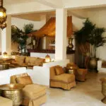 El salón está decorado en tonos blancos, crema y dorados, con iluminación auténtica y detalles en madera.