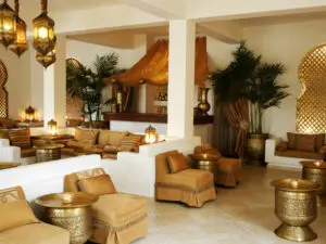 El salón está decorado en tonos blancos, crema y dorados, con iluminación auténtica y detalles en madera.