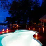 Una romántica iluminación enmarca la piscina del Kwando Lagoon Camp, situado en una de las reservas privadas más exclusivas de Botsuana.