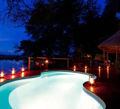 Una romántica iluminación enmarca la piscina del Kwando Lagoon Camp, situado en una de las reservas privadas más exclusivas de Botsuana.