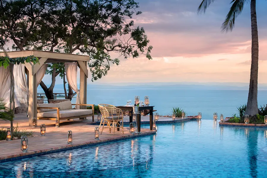 La piscina infinita de Bumi Hills, cama de día, palmera y hermosas vistas | Go2Africa