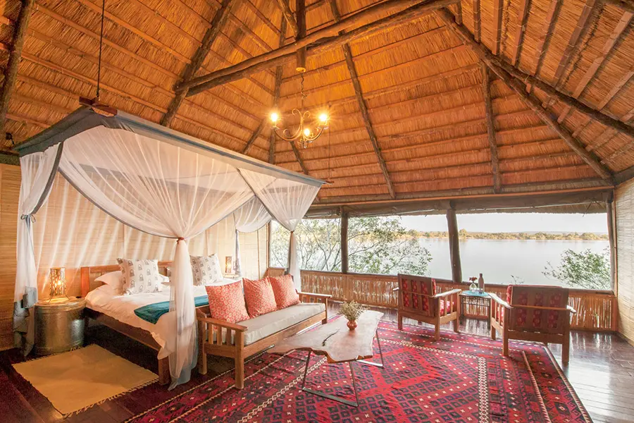 Una espaciosa suite con techo de paja con laterales abiertos y una gran vista del río circundante | Go2Africa
