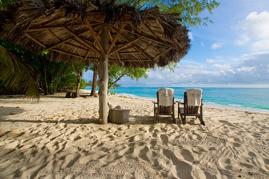 Two loungers and a thatched palapa sit on the beach overlooking the turquoise ocean | Go2Africa