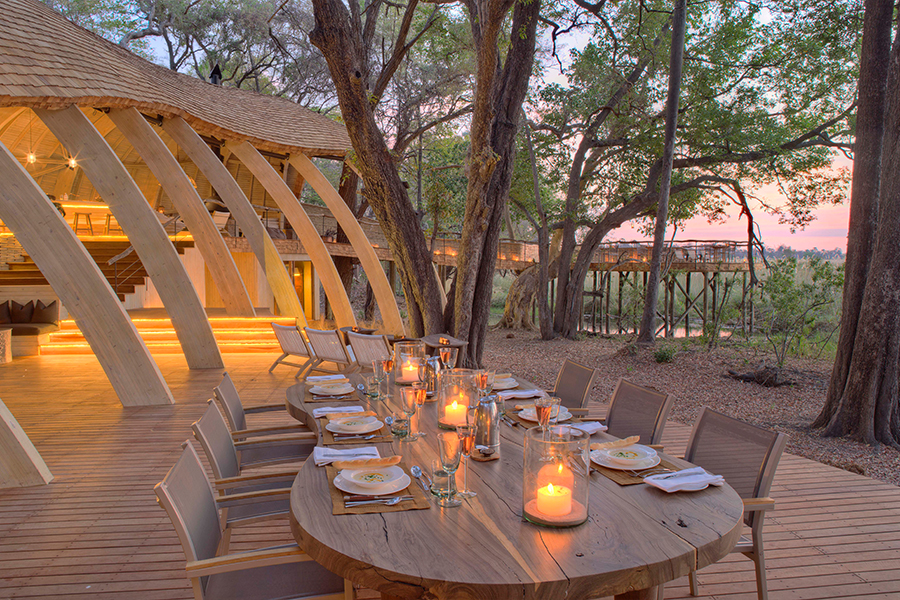 A large dining table for an al fresco meal surrounded by trees and a view over the surrounding area | Go2Africa
