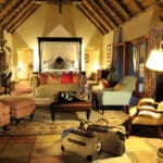 Las camas con dosel y las antigüedades coloniales crean un ambiente seductor en los campamentos Sabi Sabi.