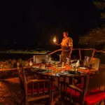 In the evening, the camp is lit up to provide a soft light over the outdoor dining area.