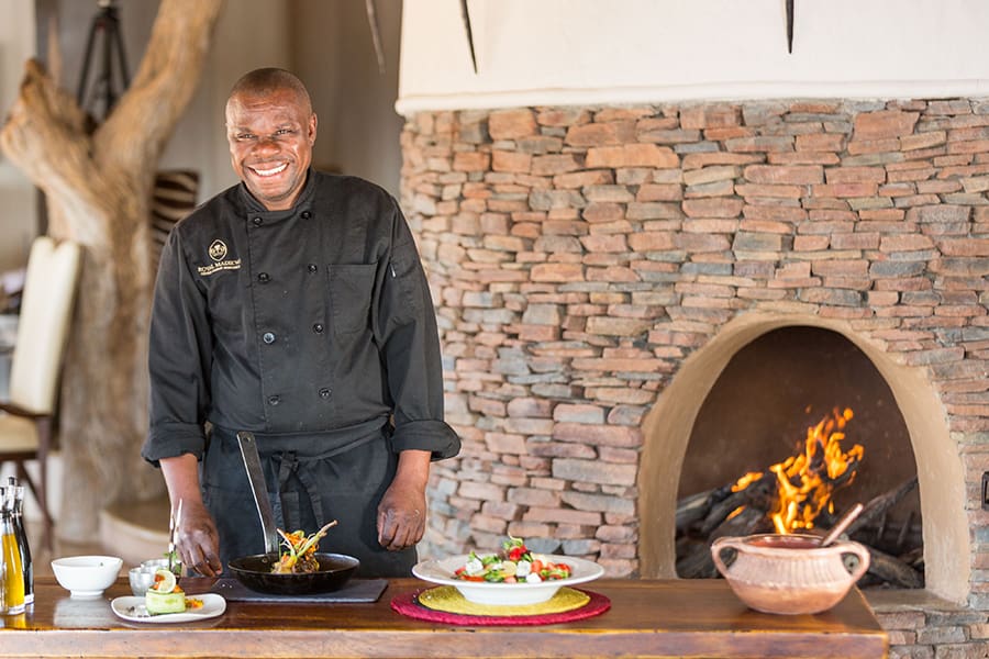 Un miembro del equipo de Royal Madikwe listo para servir comida | Go2Africa