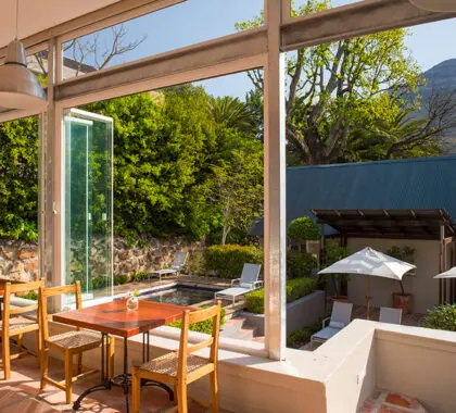 Comedor soleado con vistas al jardín y a la terraza de la piscina.