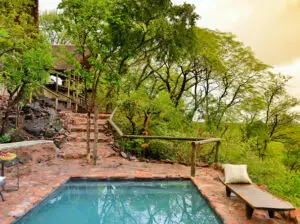 The lodge is both luxurious and rustic, with stone-laid paths leading to the suites and swimming pool.