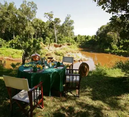 Disfrute de una comida en la sabana con vistas al río Mara.