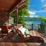 La veranda de una villa frente al mar, acogedora y serena.