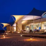 The camp's sensual, clean-lined design looks even better when illuminated at night.