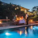 On a warm clear evening, enjoy a poolside dinner setup.