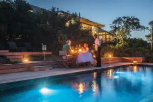 On a warm clear evening, enjoy a poolside dinner setup. 