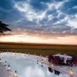 La luz de las lámparas ilumina una cena privada en Kichwa Tembo; el Masai Mara sirve de telón de fondo.