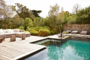 A swimming pool surrounded by a beautiful garden.