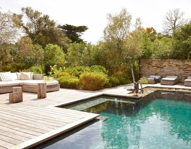A swimming pool surrounded by a beautiful garden.