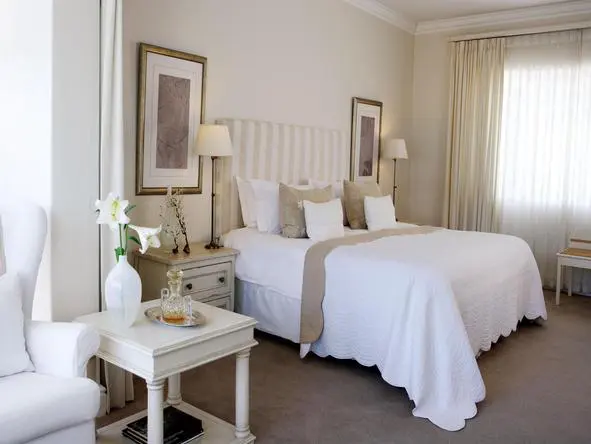 Leisure Isle Lodge dispone de varias habitaciones de lujo, todas con muebles de madera clara y decoradas en crema y blanco.