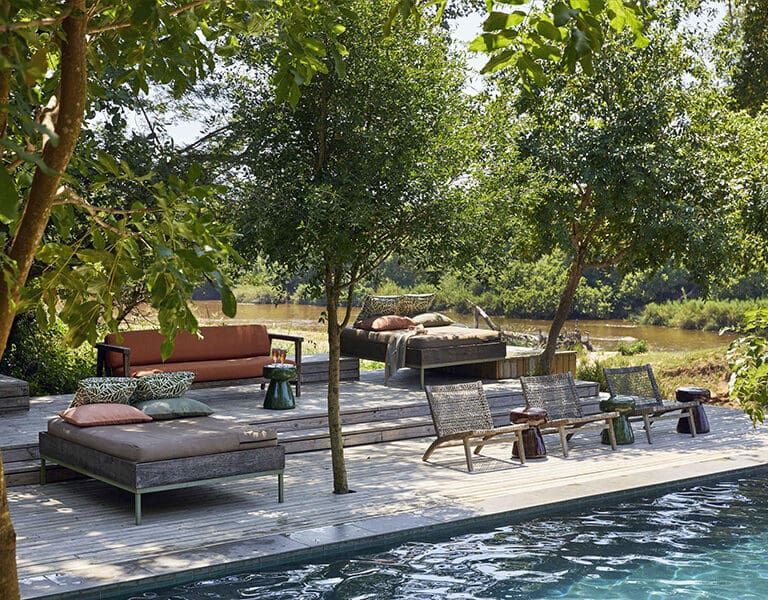 The pool and loungers next to the river.