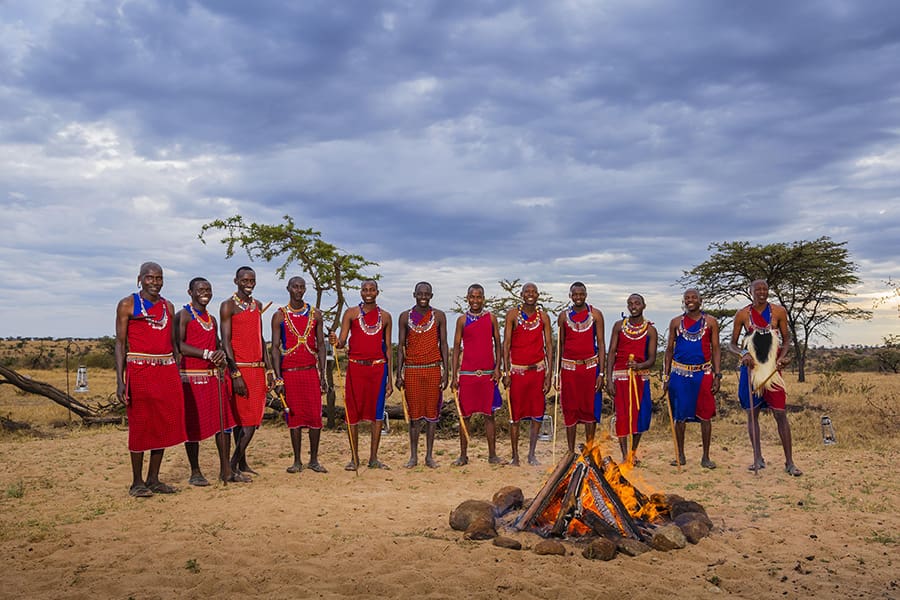 A group of Maasai gather around a fire at Mahali Mzuri Camp