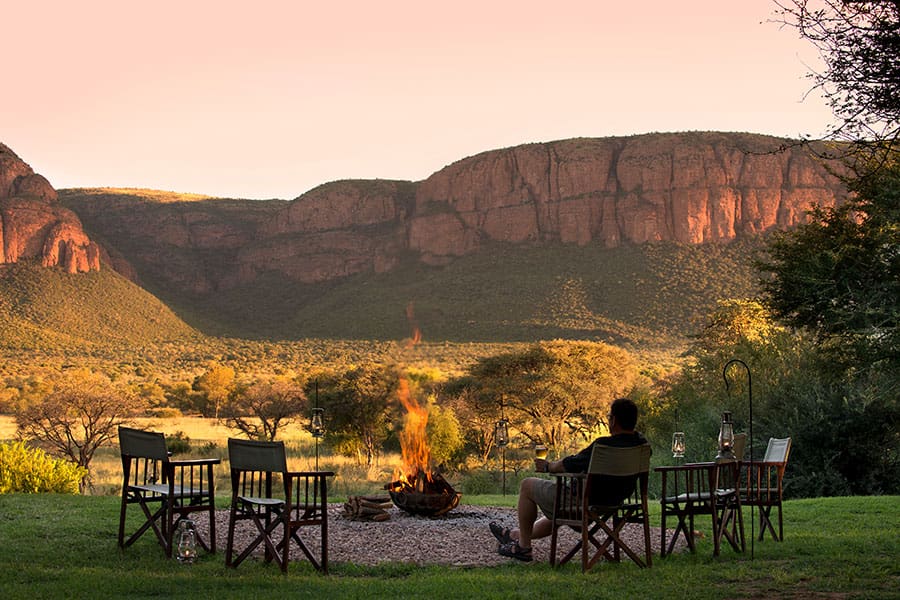 Tables set up around a firepit overlooking the mountains in Marataba | Go2Africa