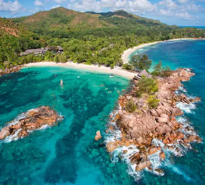 Aerial view of Lemuria's pristine beach and secluded cove. 