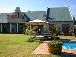 La casa de huéspedes es de estilo Karoo clásico, con un gran jardín y una piscina en la parte delantera.