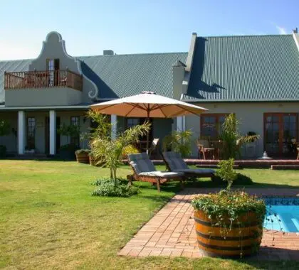 La casa de huéspedes es de estilo Karoo clásico, con un gran jardín y una piscina en la parte delantera.