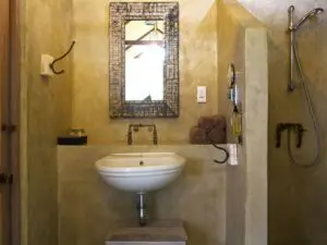 The large bathroom has a big window and the shower offers views into the surrounding bush