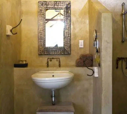 L'ampio bagno ha una grande finestra e la doccia offre una vista sulla boscaglia circostante.