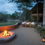 Tras disfrutar de una copa alrededor de la hoguera al aire libre, deguste una cena recién preparada a la luz de los faroles.