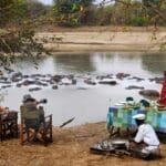 Tras su safari a pie matutino, disfrute de un merecido almuerzo servido a orillas del río.