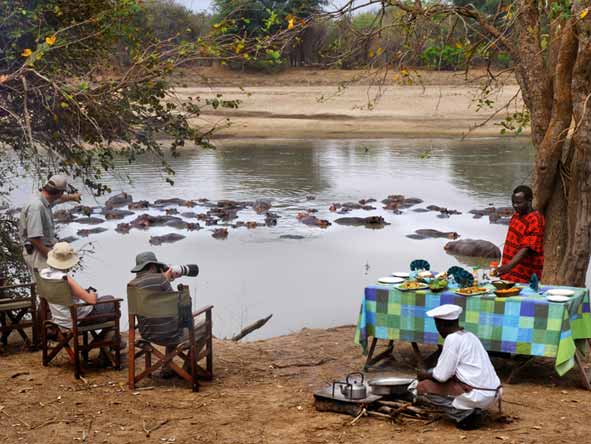 Tras su safari a pie matutino, disfrute de un merecido almuerzo servido a orillas del río.