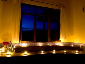 Observa cómo parpadean las velas de la habitación mientras te das un relajante baño en la gran bañera.