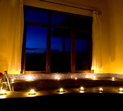 Observa cómo parpadean las velas de la habitación mientras te das un relajante baño en la gran bañera.