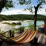 Una terraza de madera con hamaca y vistas a la playa: el lago Malawi es un paraíso tropical de playa en el corazón de África.